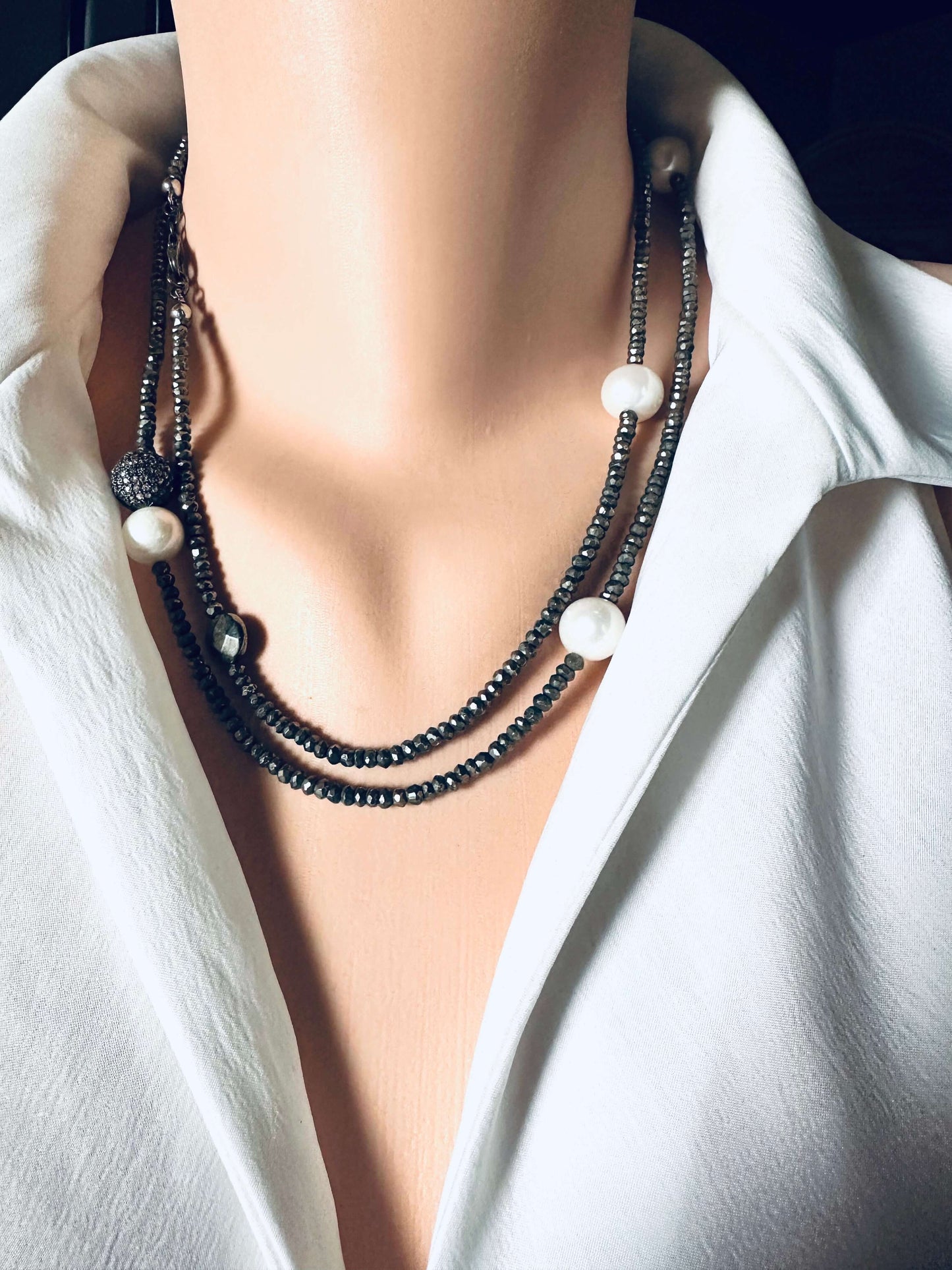 Long pyrite and pearl necklace with pavé accent in oxidized silver worn on a mannequin.