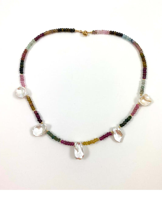 A beaded necklace featuring a multicolor strand of small beads with irregular, clear teardrop-shaped pearl pendants, displayed on a plain white background.