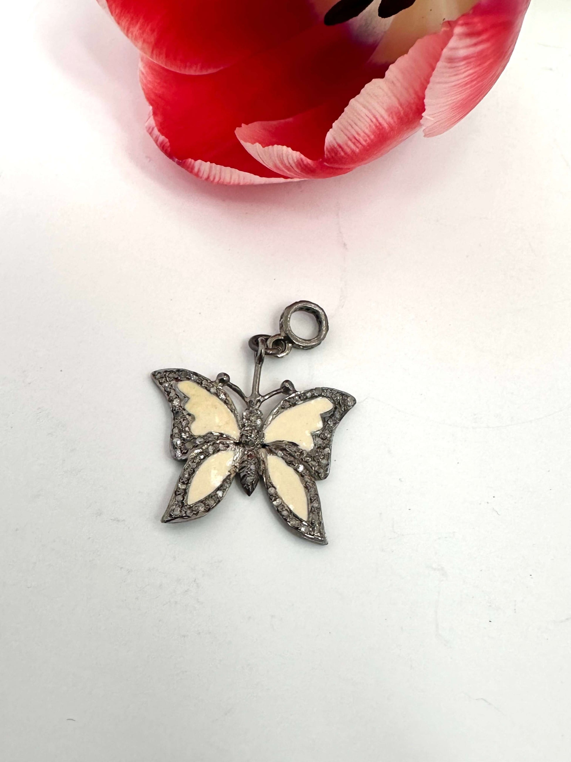 Enamel butterfly pendant with diamond pavé in sterling silver, featuring soft off-white enamel wings.
