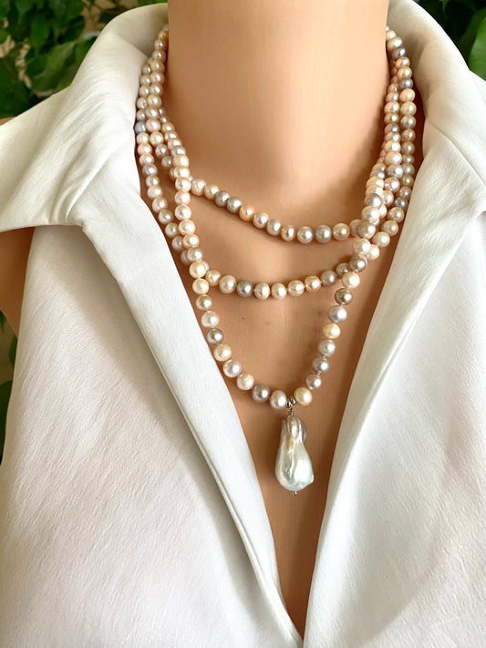 Pearl necklace with a large white pearl pendant on a white outfit.