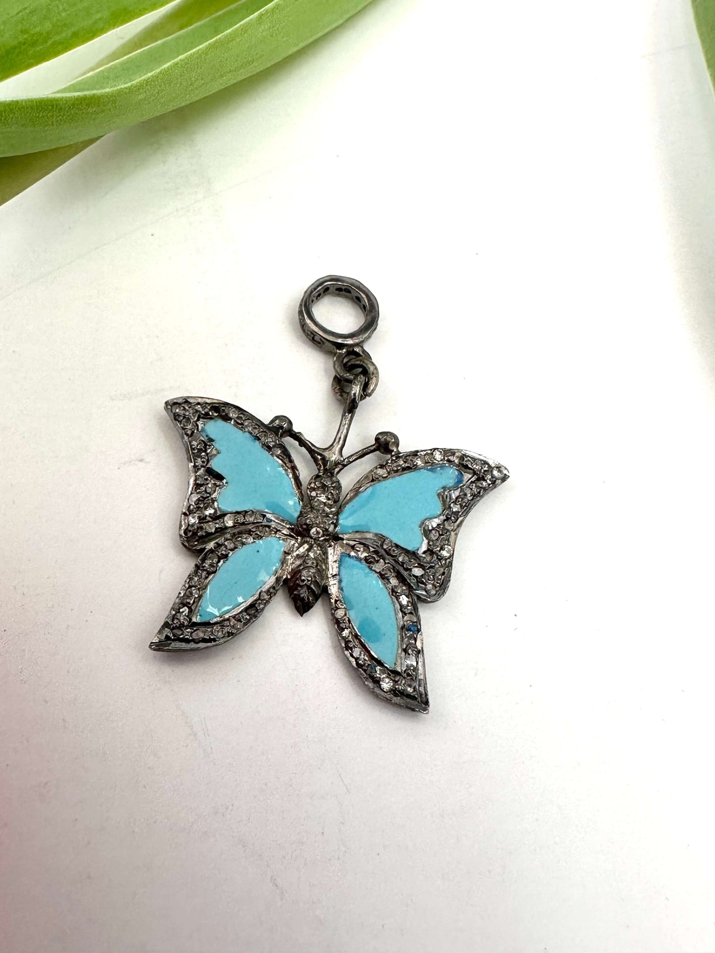 Blue enamel butterfly pendant with diamond pavé in sterling silver, displaying vibrant blue wings and sparkling detail.
