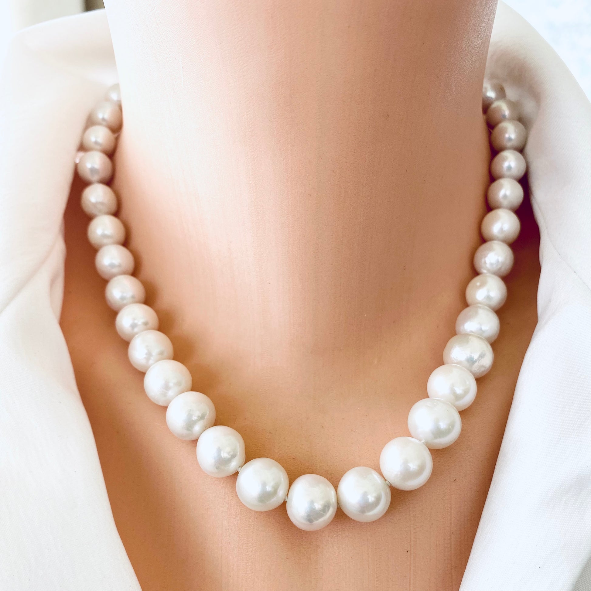 Edison pearl necklace with graduated white pearls showcased on a mannequin, featuring a heart pavé diamond clasp.