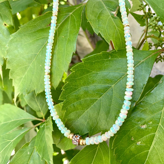 Ethiopian opal necklace hanging on green leaves, smooth rondelle opal beads with gold vermeil details