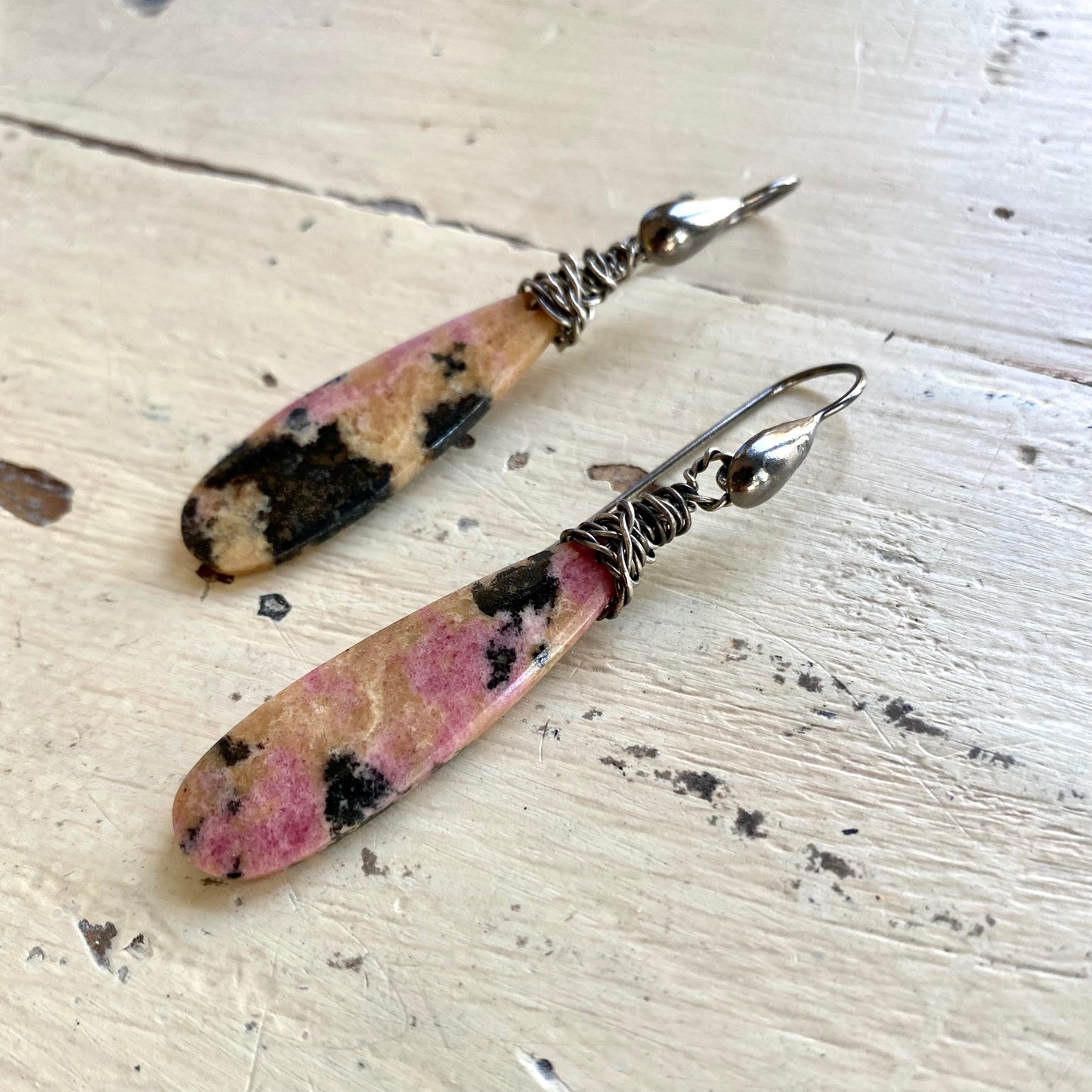 Rhodonite Teardrop Earrings – Black Rhodium Finish featuring unique pink rhodonite stones with black and yellow veining.
