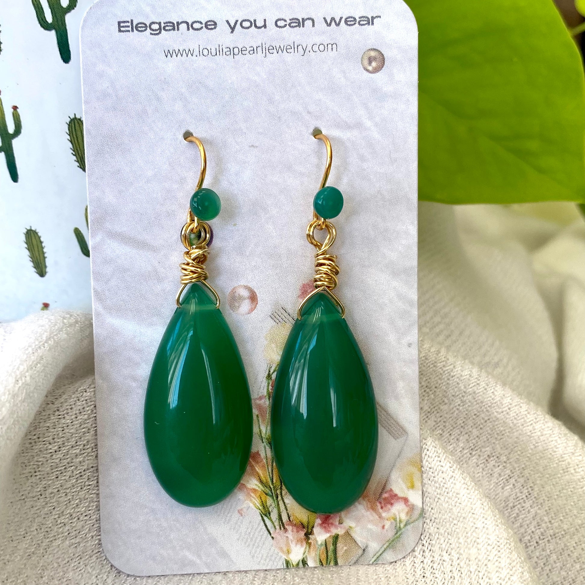 Emerald green onyx teardrop earrings on display card with gold vermeil hooks