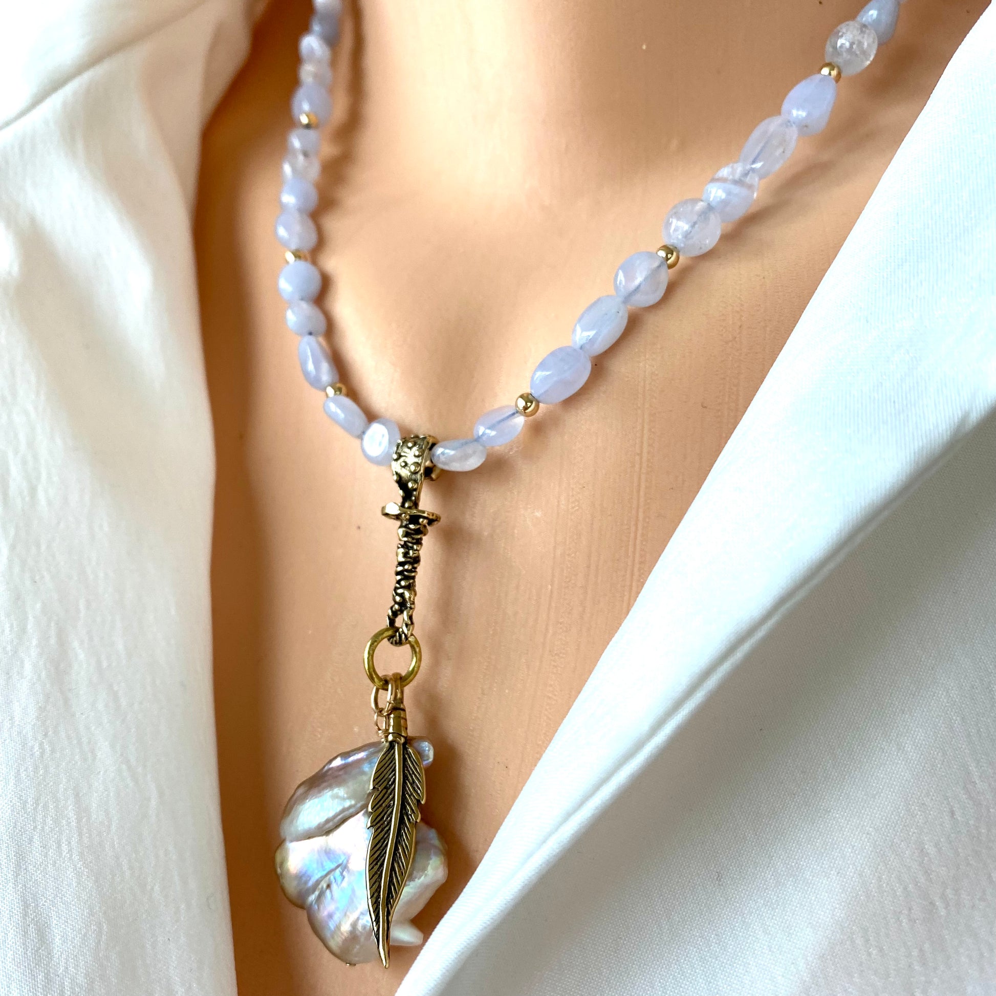 Blue lace agate pearl necklace worn at the neckline with keshi baroque pearl pendant and leaf charm