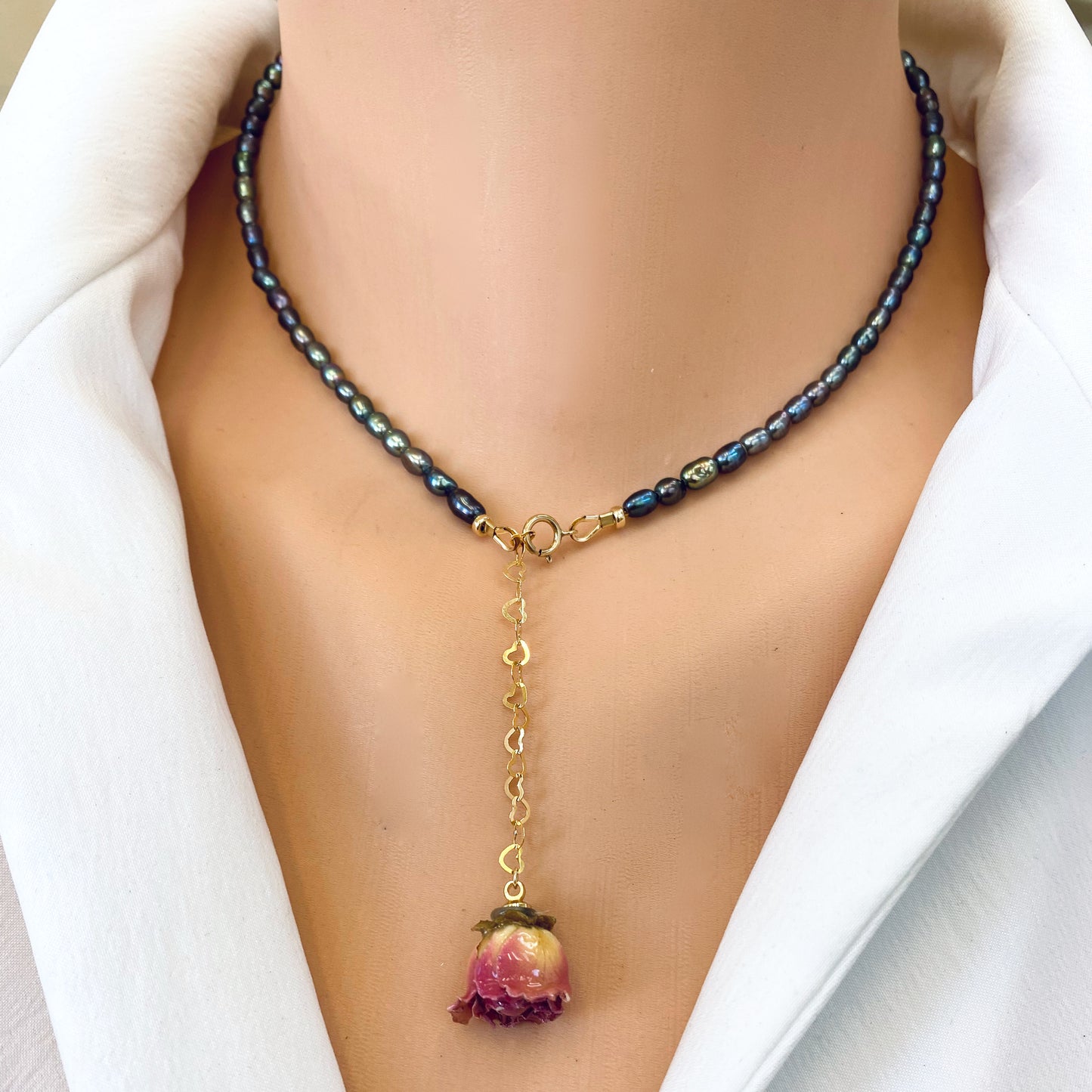 Pink Rosebud Pearl Necklace featuring black rice pearls and a preserved pink rosebud charm