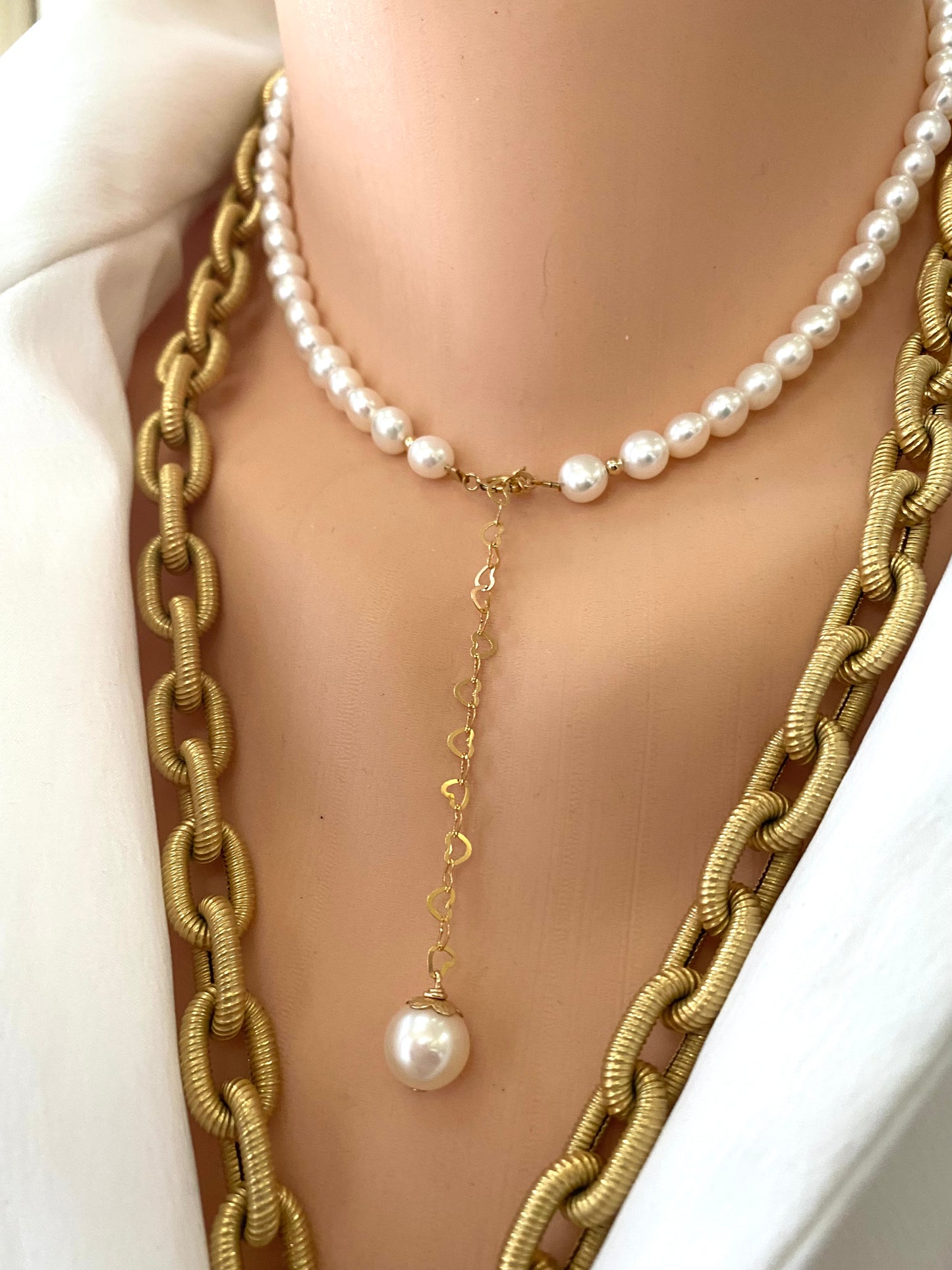 Pearl heart necklace layered with gold chain showing pearl charm and heart chain detail