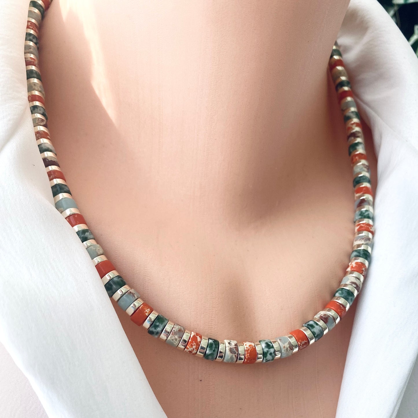 Gemstone choker necklace with multi color beads and hematite worn on a mannequin's neck, showcasing vibrant design.