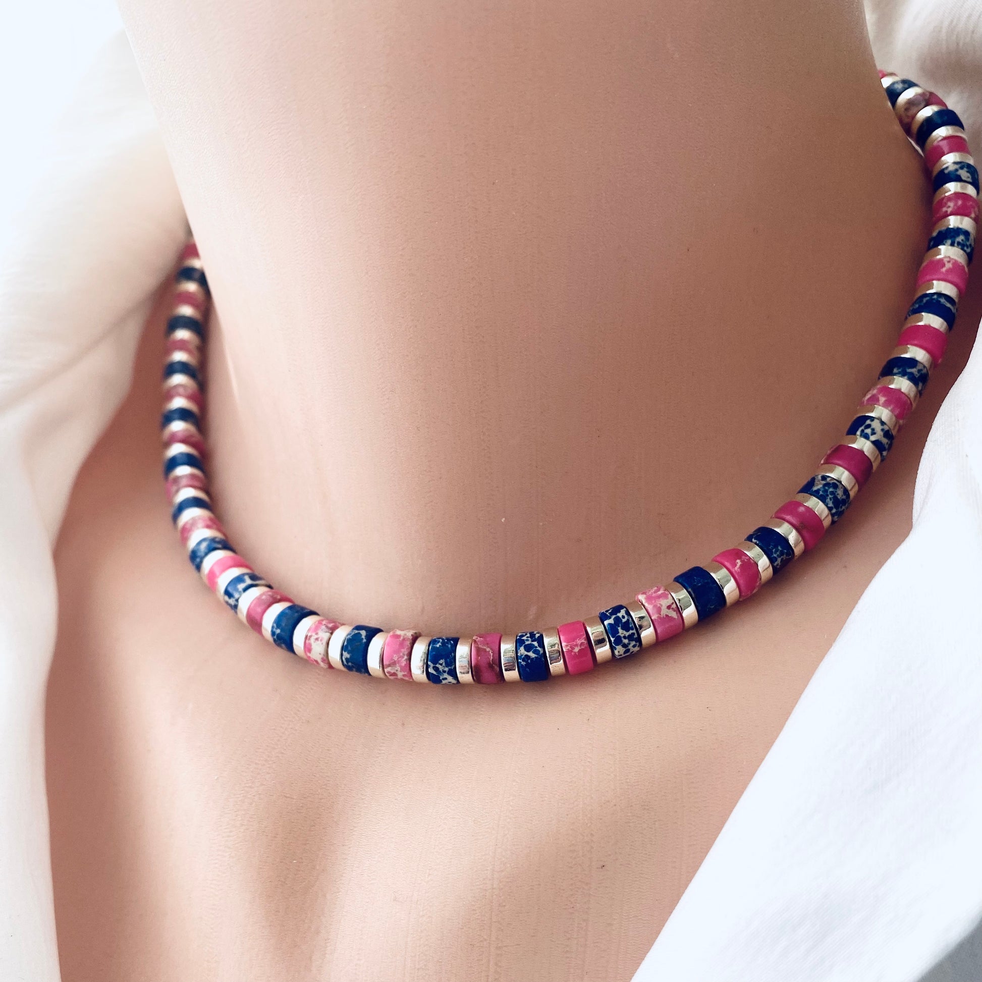 Gemstone choker necklace with multi color beads showcasing vibrant designs worn on a neck mannequin.