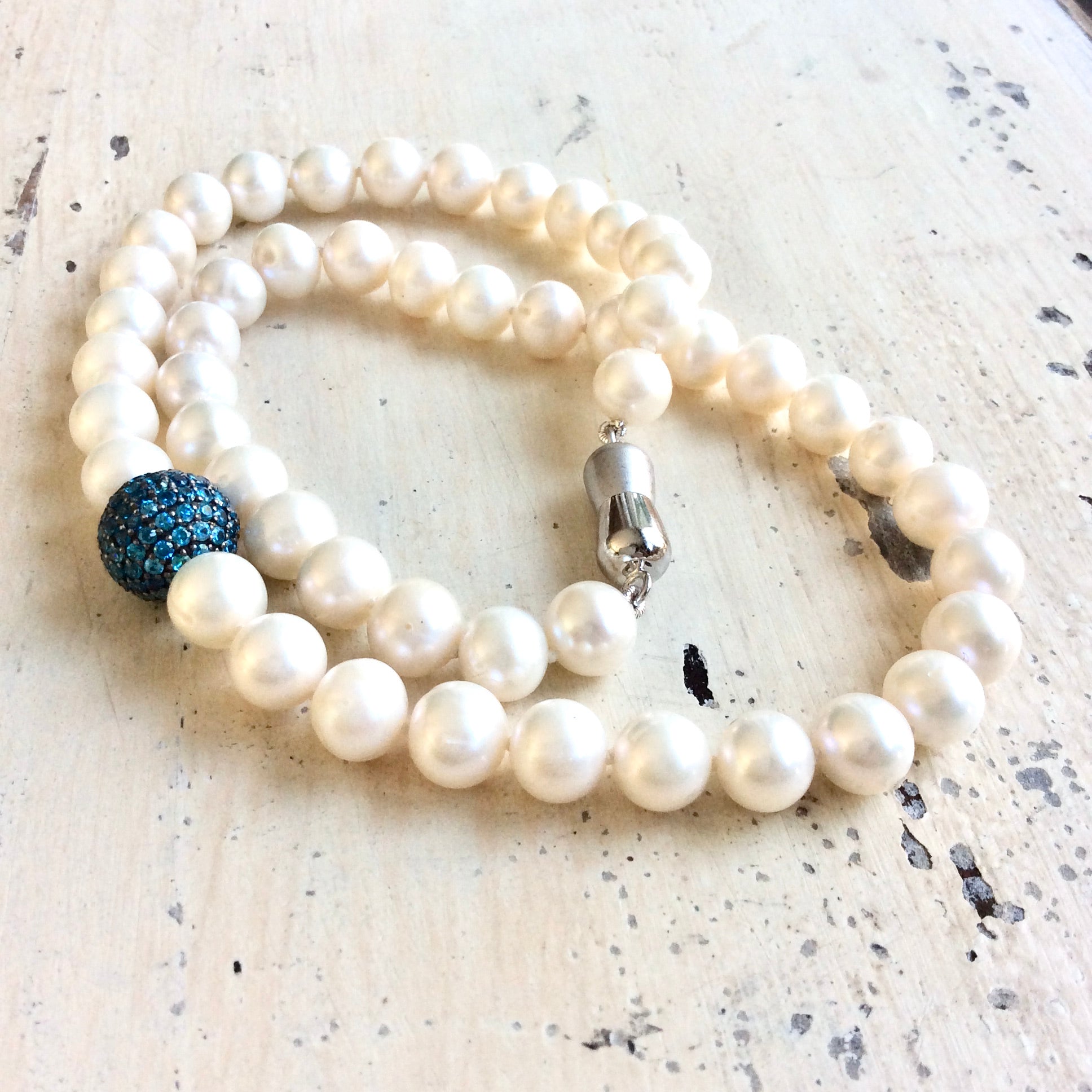 Pearl necklace with turquoise CZ bead, handmade in Canada featuring lustrous freshwater pearls.