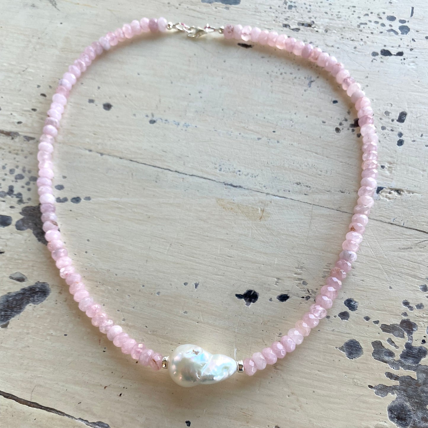 Rose quartz pearl necklace displayed flat with silver clasp and baroque pearl centerpiece, handmade Canadian jewelry