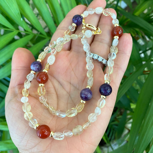 Citrine bonbons necklace with amethyst and carnelian accents held in hand, handmade gemstone jewelry from Canada