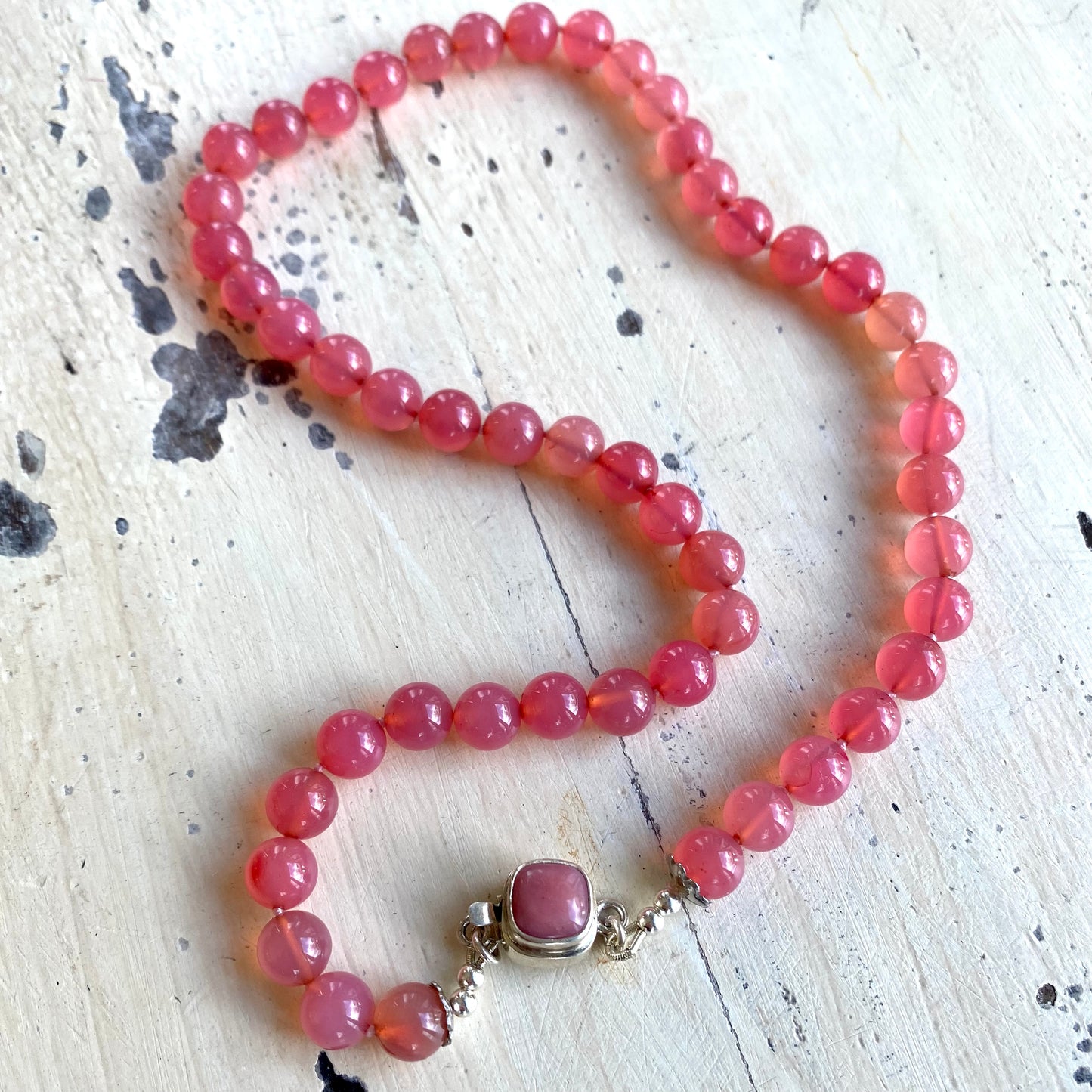 Strawberry quartz cherry necklace laid flat, hand-knotted candy gemstone jewelry made in Canada