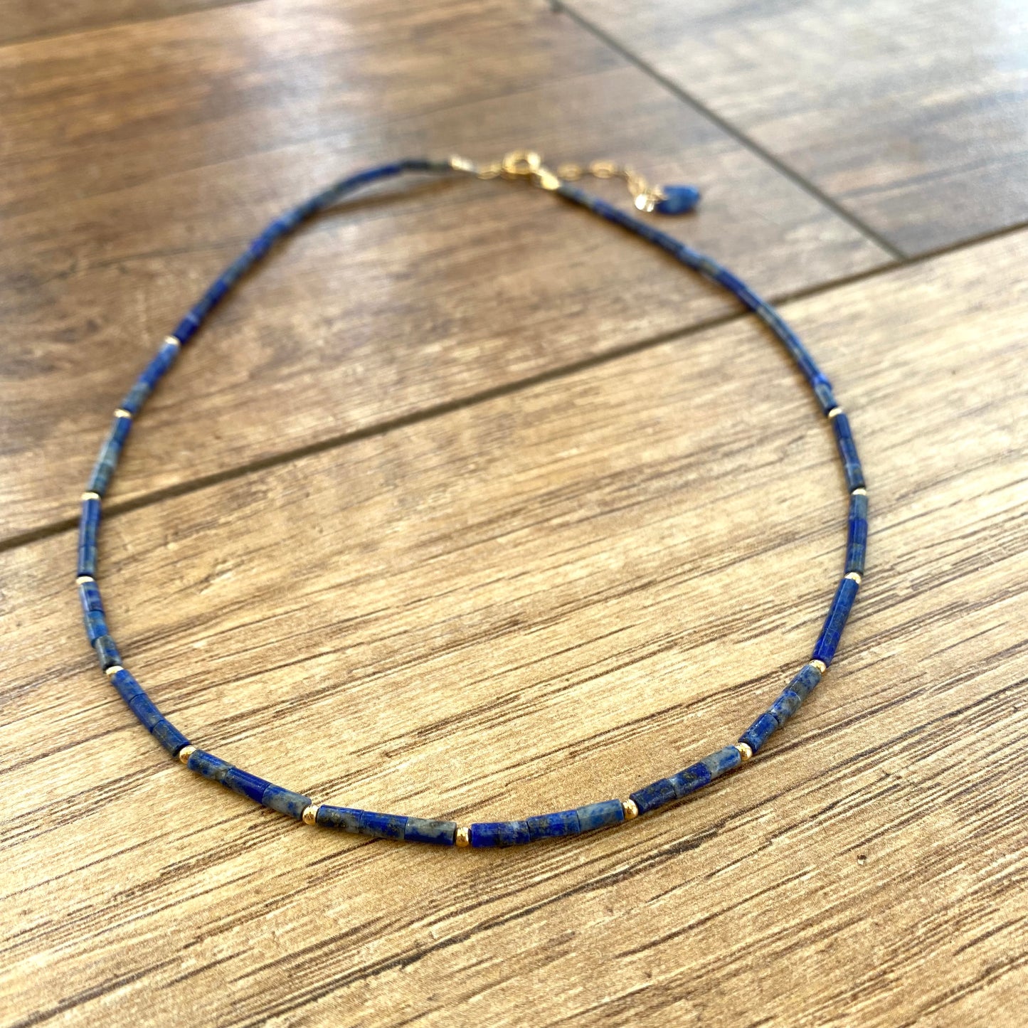 Lapis lazuli onyx choker necklace displayed flat with blue lapis tube beads