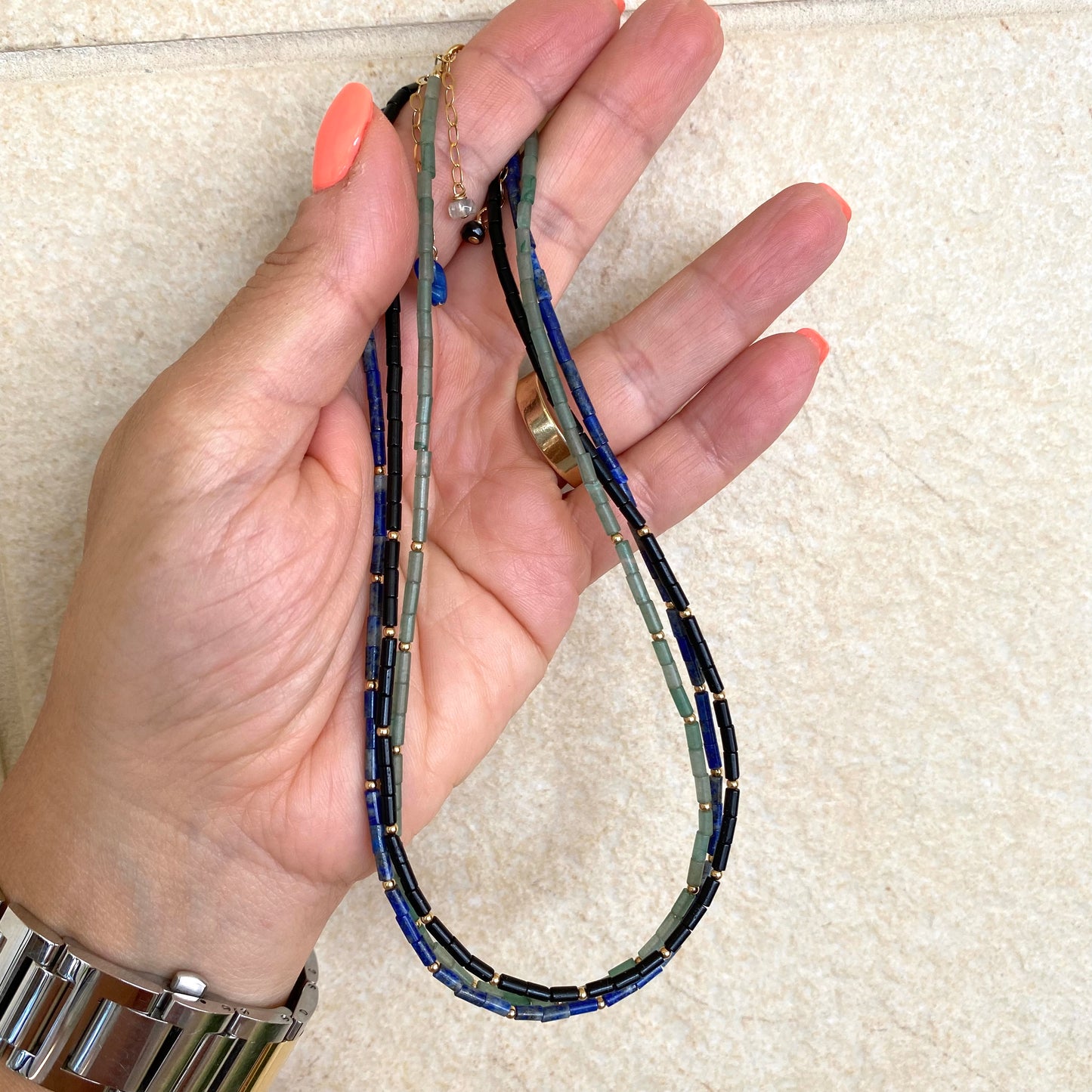 Lapis lazuli onyx choker necklace held in hand highlighting tube bead design