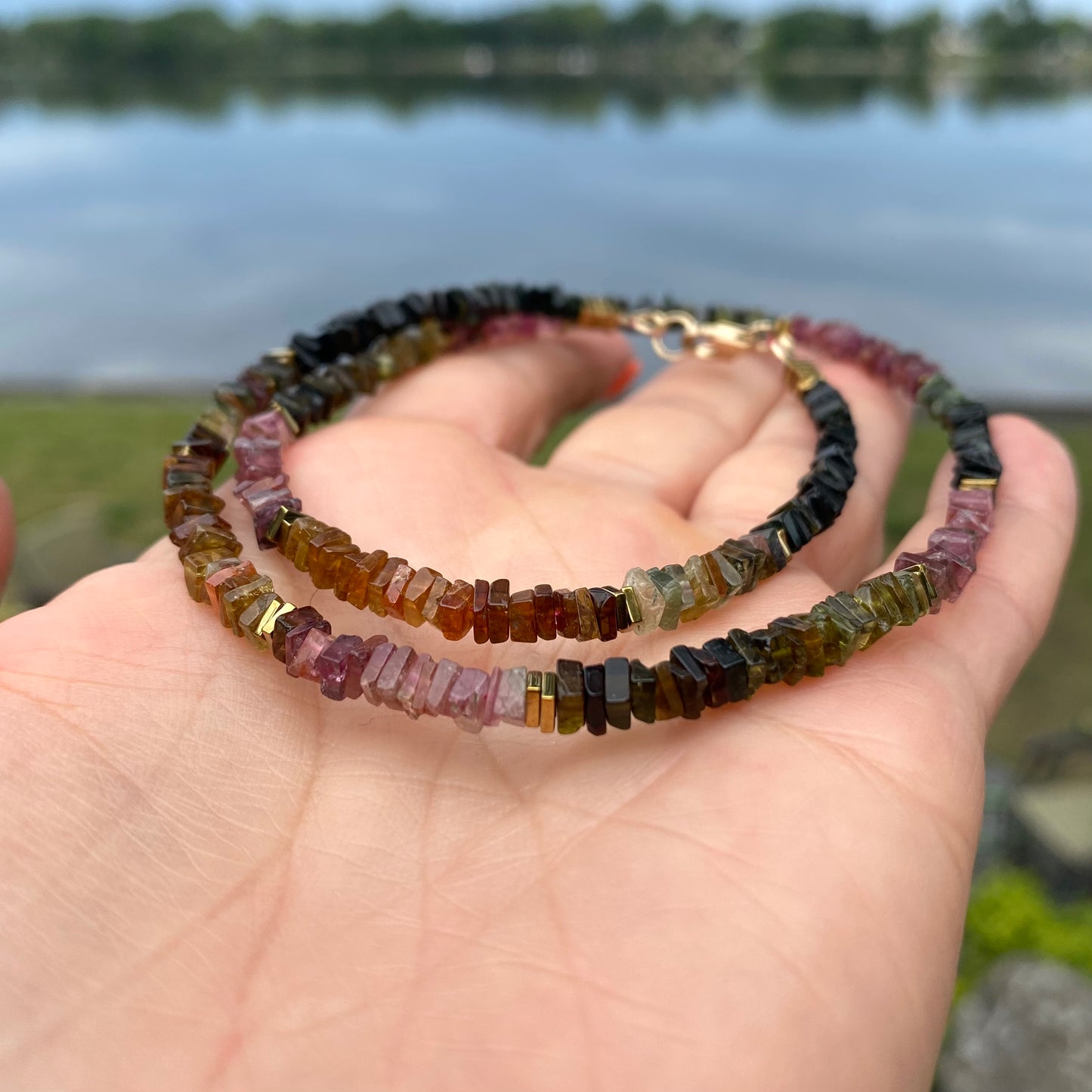 Tourmaline Necklace 14k Gold Filled in hand, watermelon tourmaline beads close-up by the water