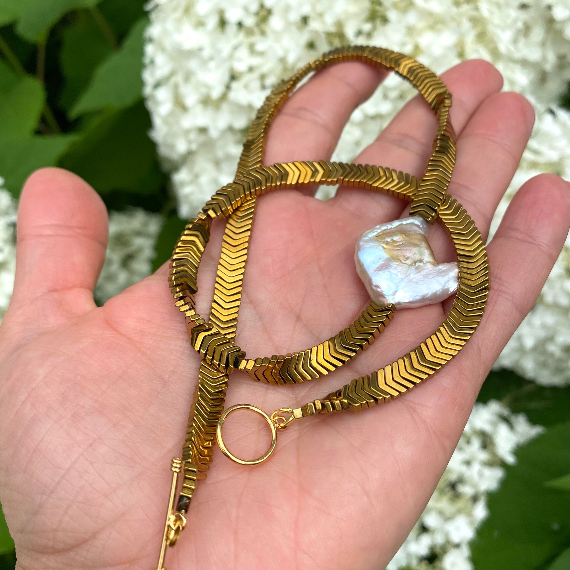 Gold hematite keshi pearl necklace held in hand highlighting thick gold hematite chain design
