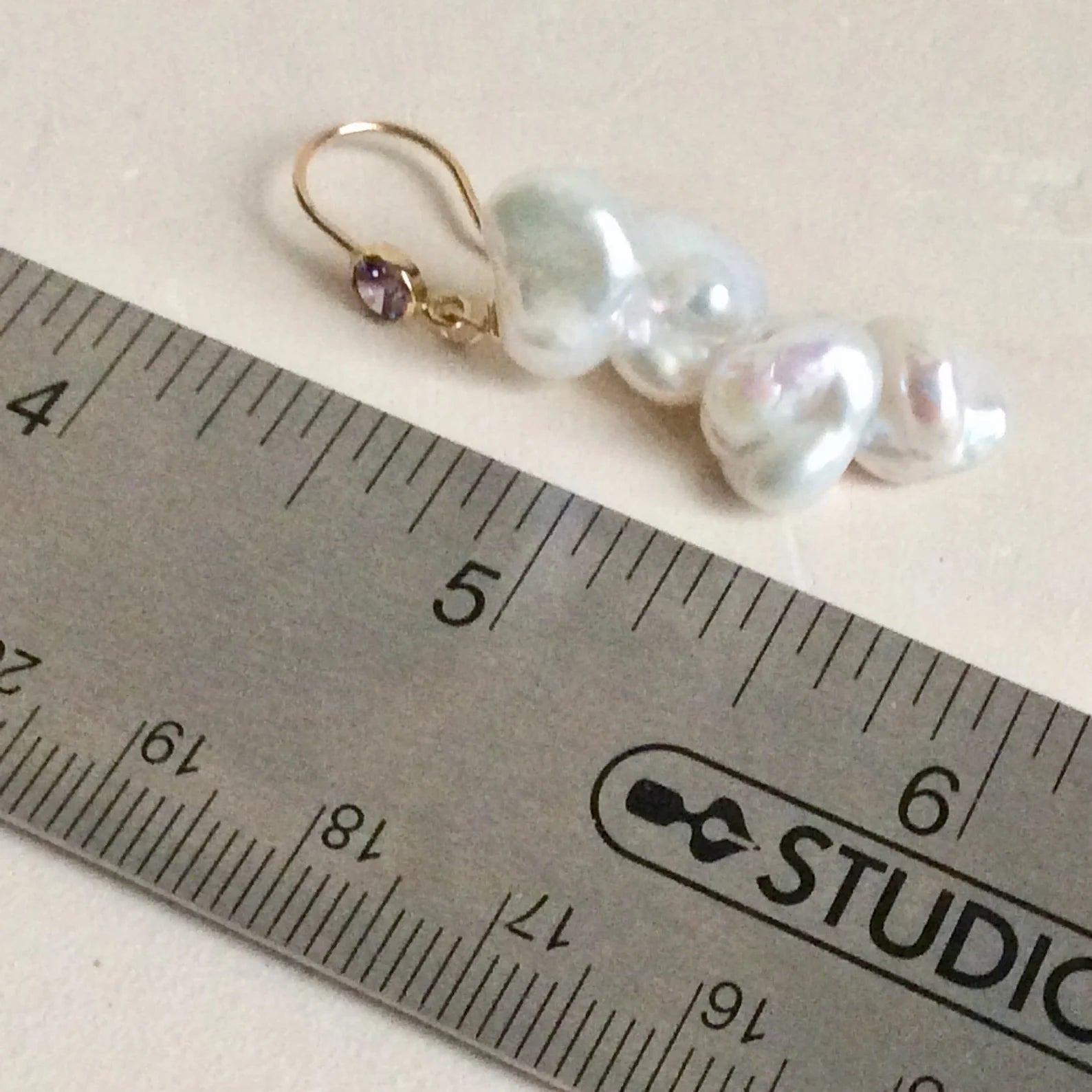 Keshi Pearl Drop Earrings featuring white freshwater keshi pearls and purple CZ, showcased next to a ruler for size reference.