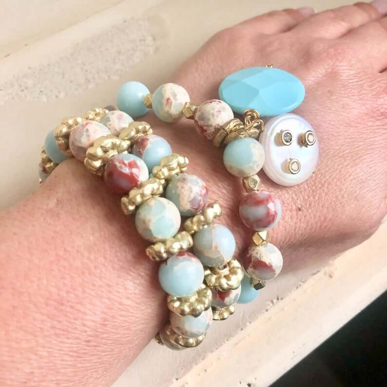 Pale blue deep red stretchy bracelet stack worn featuring turquoise coin charm and pearls